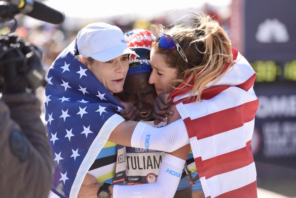 Competitive runners Aliphine Tuliamuk, Kellyn Taylor, and Stephanie Bruce hugging